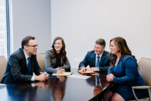 A group of attorneys sitting at a conference table. From left to right: Timothy E. Jackson, Jessica Wieczorkiewicz, Nicholas P. Kelly, Molly Condon Wells.