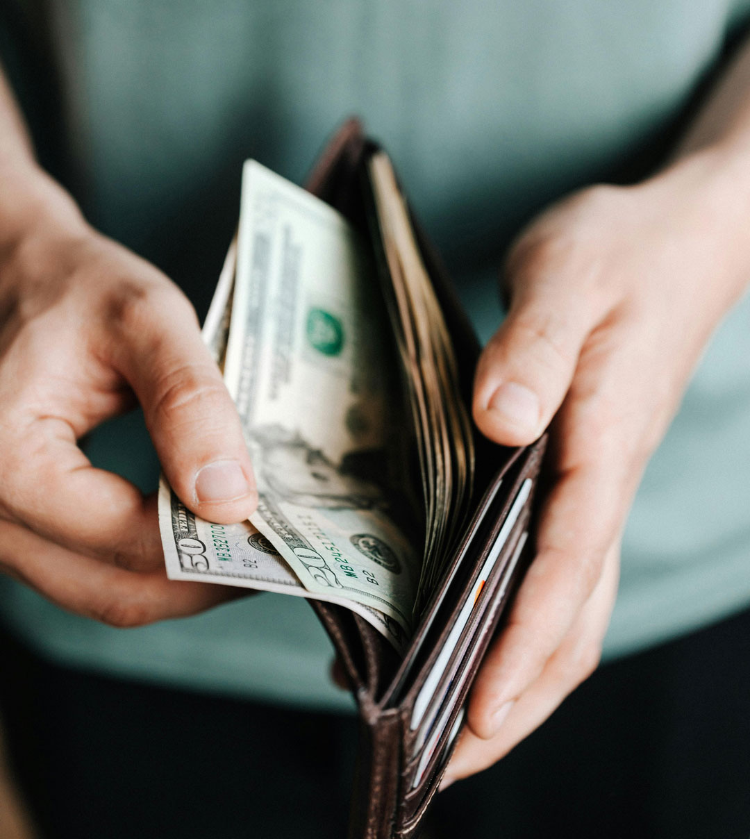 Crop man getting dollars from wallet