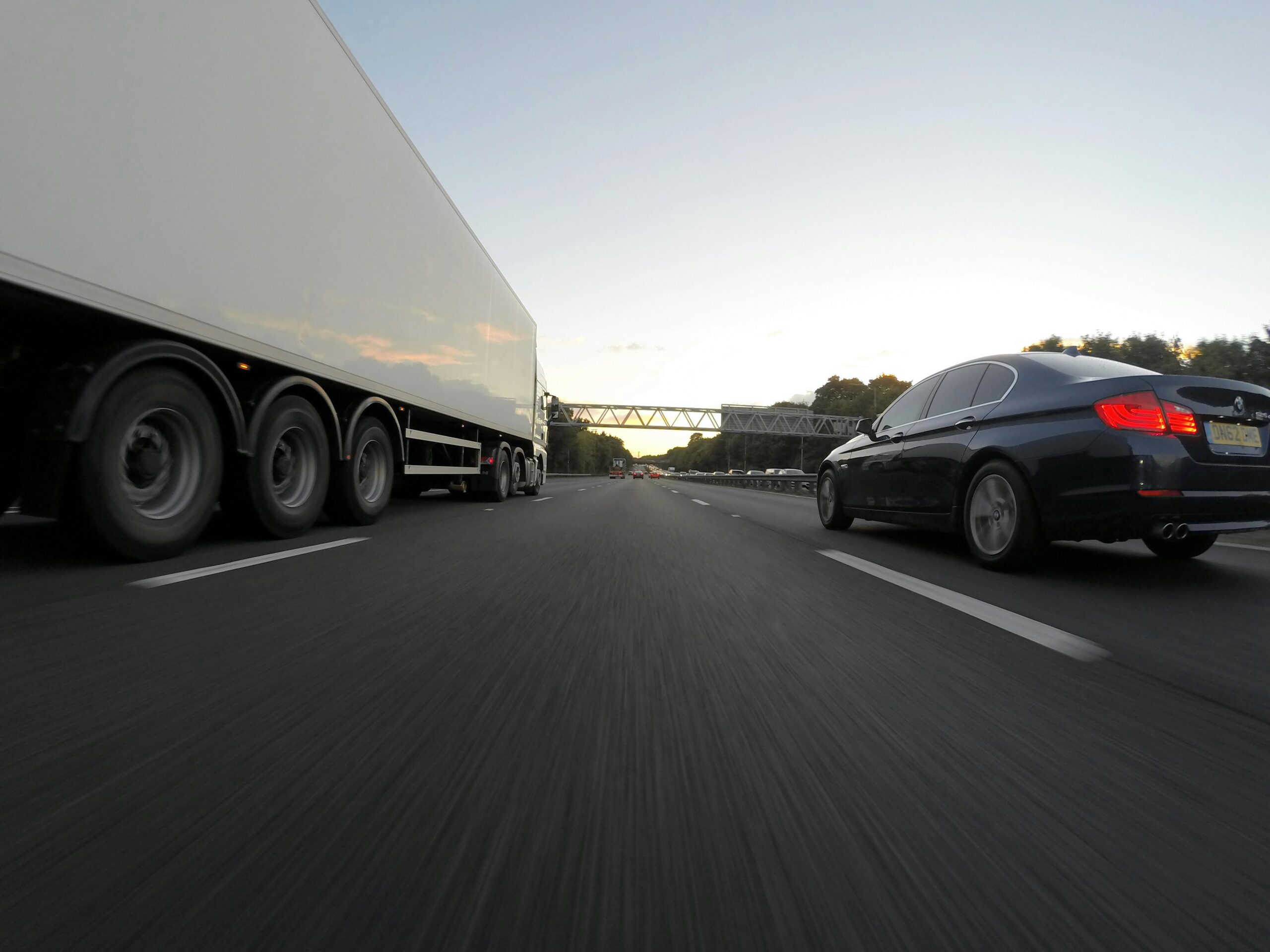 Sedan on Road With Freight Truck Photo by Mike Bird | Pexels 928201