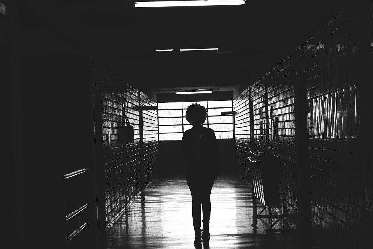 Young woman walking in dark hallway