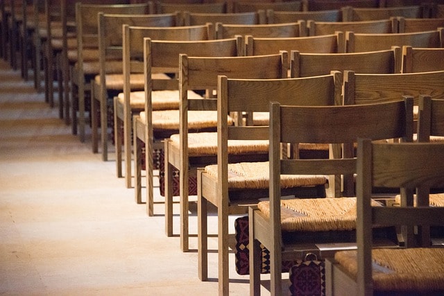 Wooden chairs in rows facing forward.
