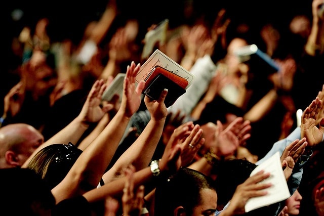 Hands lifted in the air during a worship service.