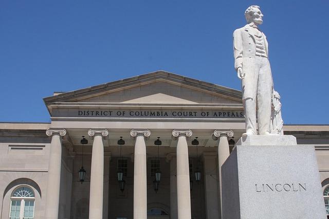 A statue of Abraham Lincoln in front of a courthouse.