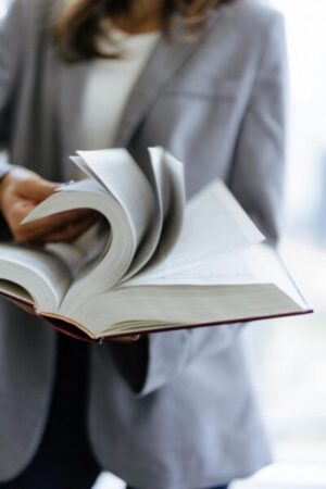 A standing person flips through a law book.